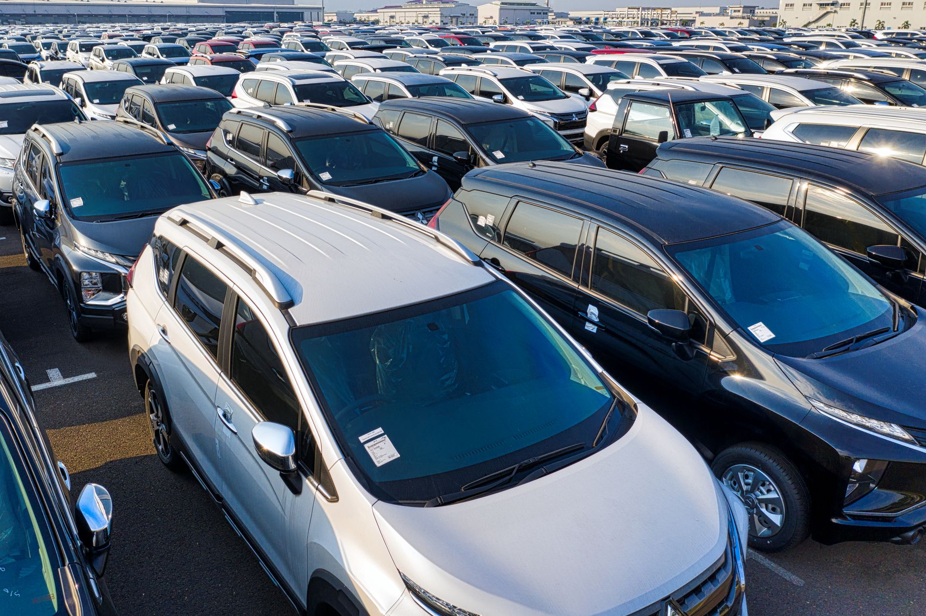Pátio de revenda com carros usados estacionados lado a lado