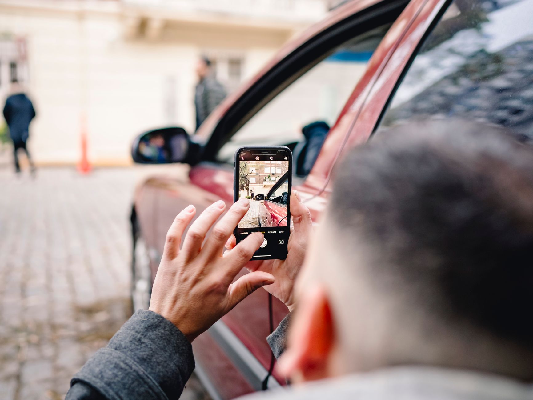 Pessoa fotografando um carro com o celular antes de negociar
