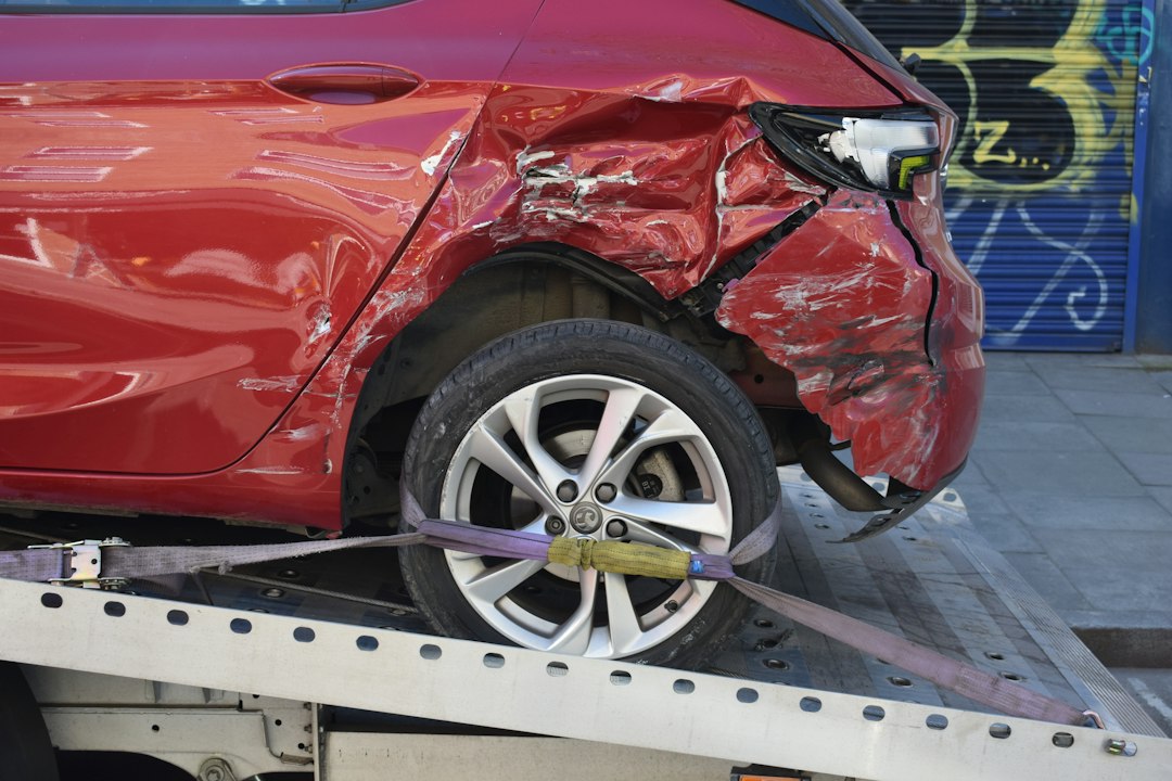 Carro vermelho com a lateral danificada sobre um guincho
