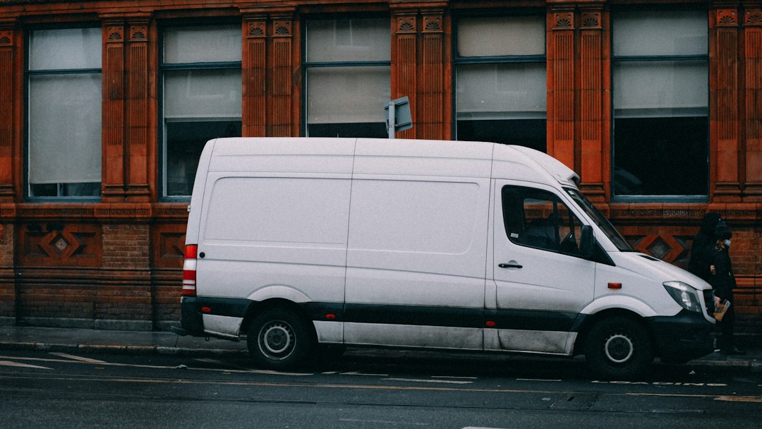 Van branca de empresa estacionada na rua