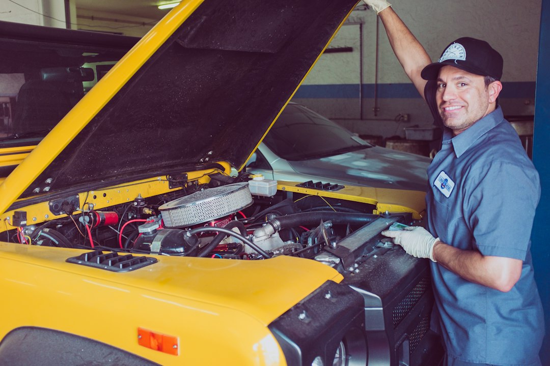 Mecânico inspecionando o motor de um carro com o capô aberto