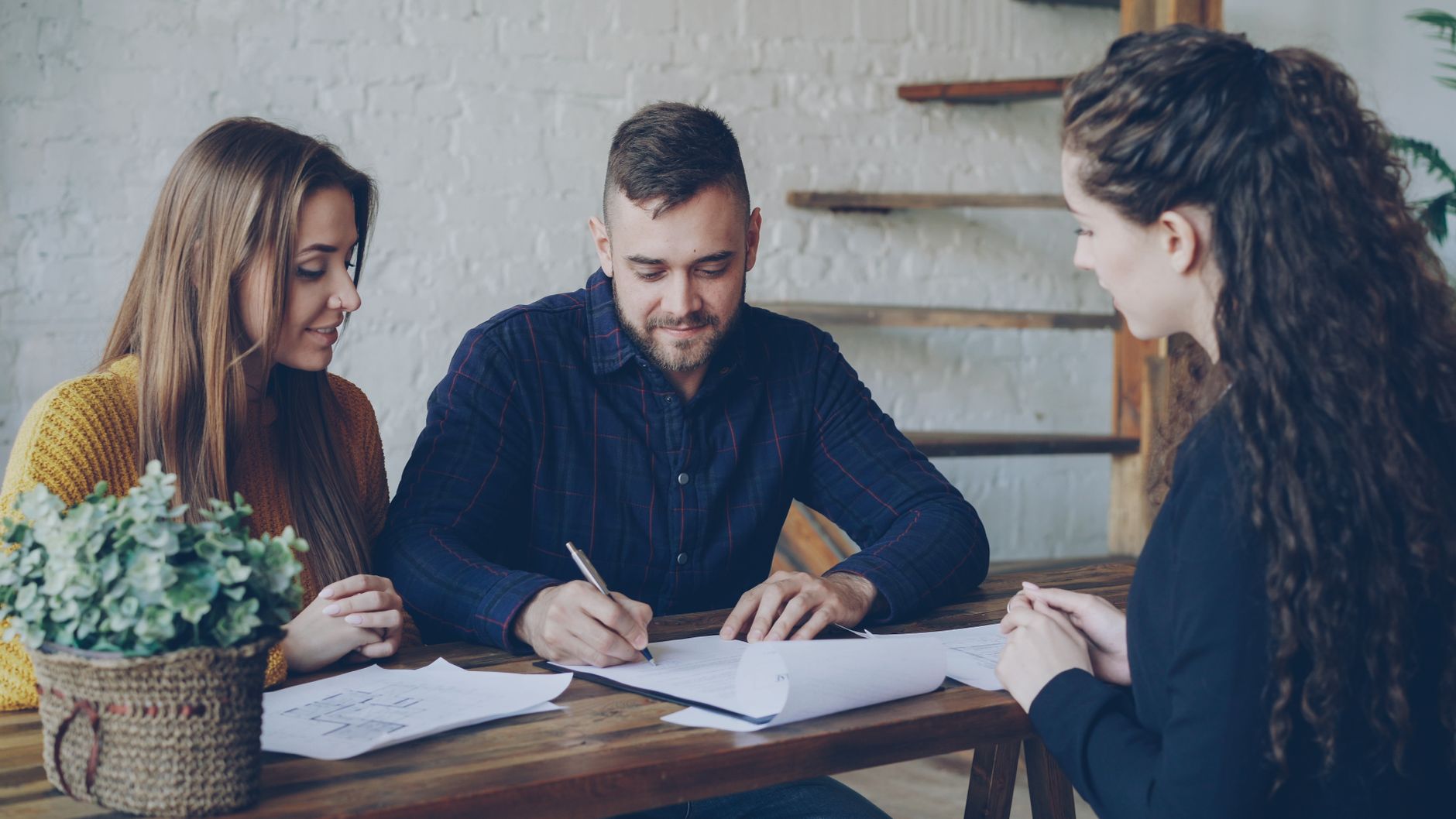 Casal assinando contrato com uma consultora
