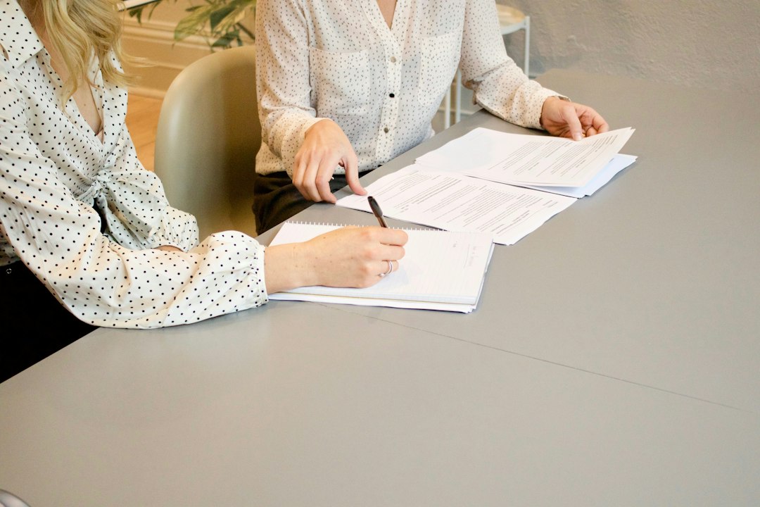 Duas pessoas lendo e assinando um contrato