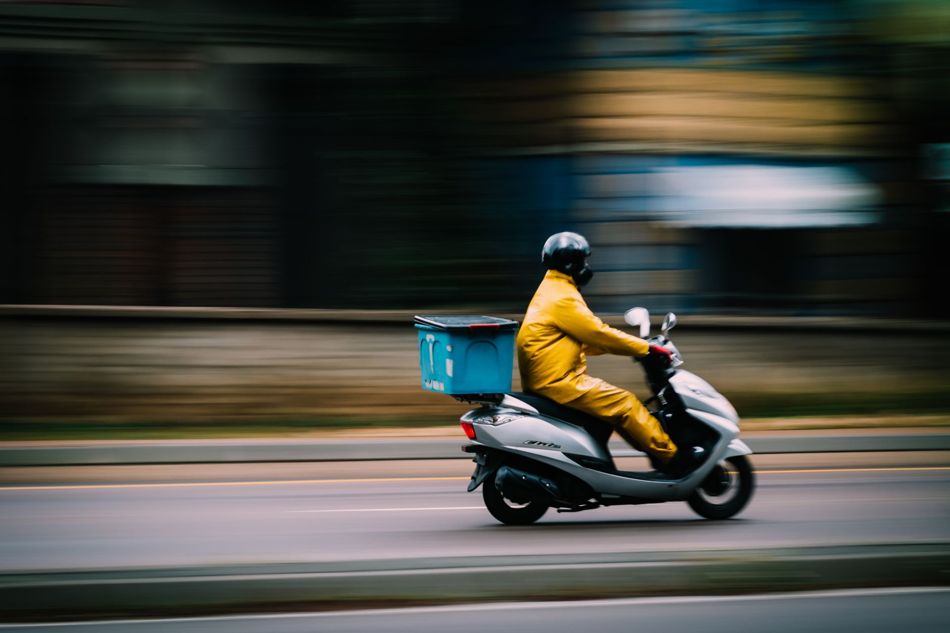 Entregador de moto em movimento na cidade