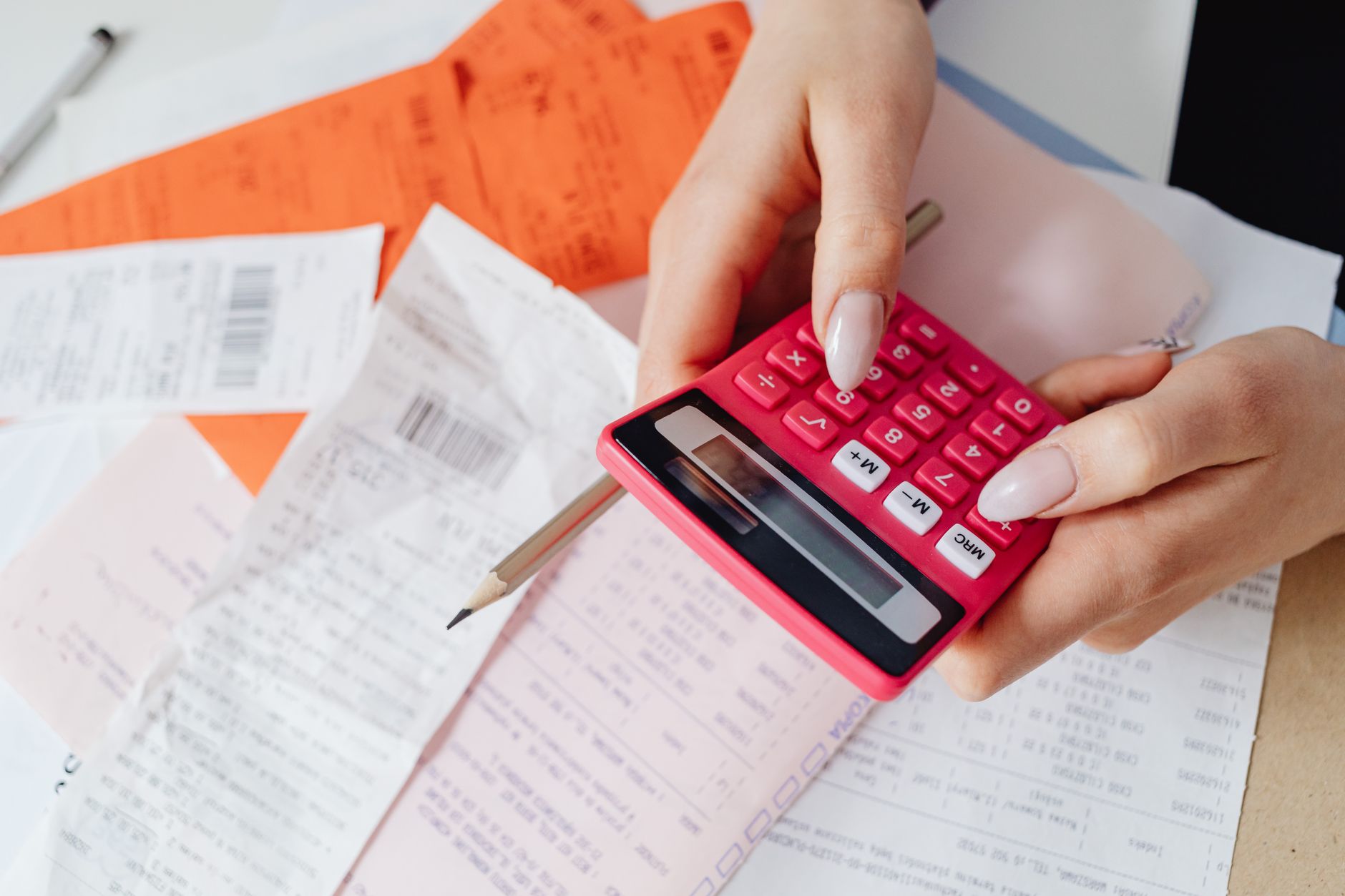 Pessoa conferindo contas com uma calculadora