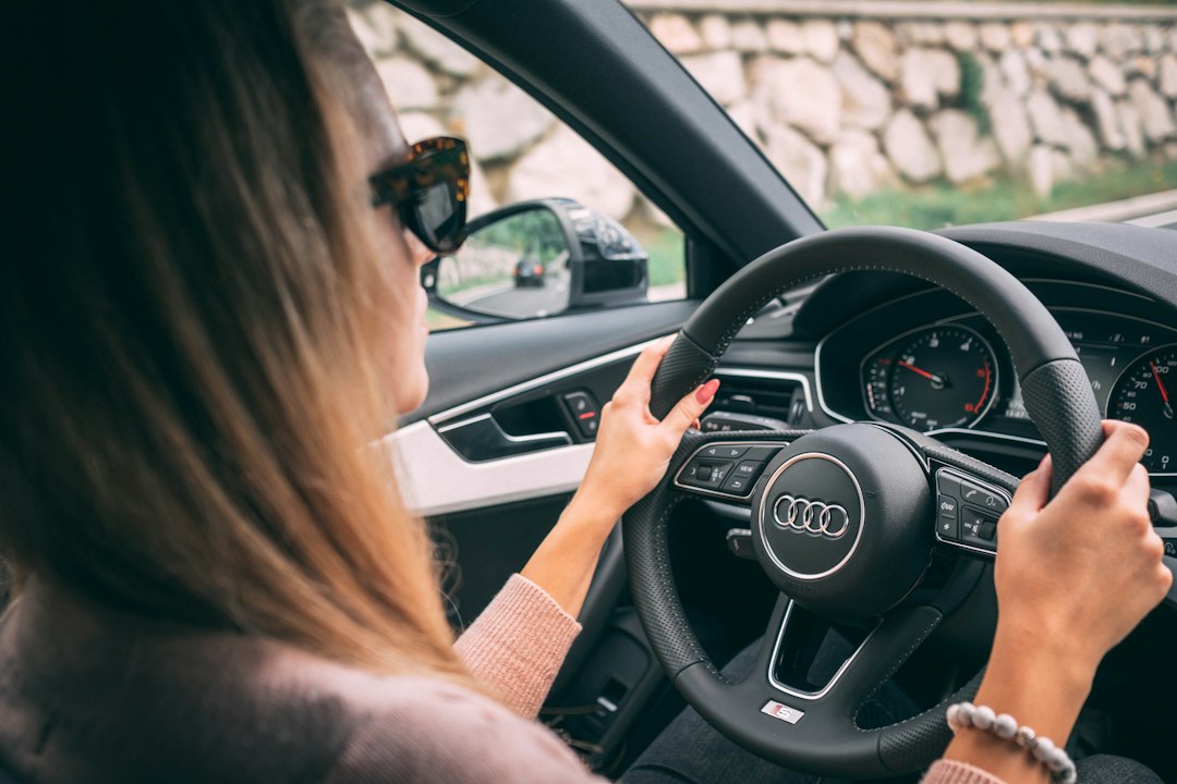 Mulher dirigindo um carro com as duas mãos no volante