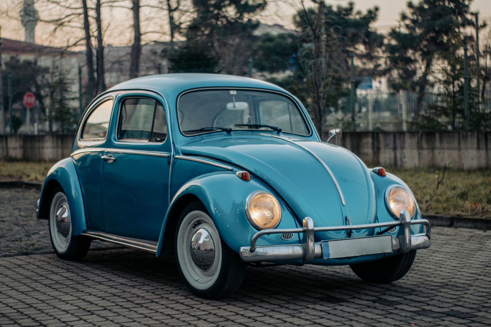 Fusca azul estacionado em rua de paralelepípedo