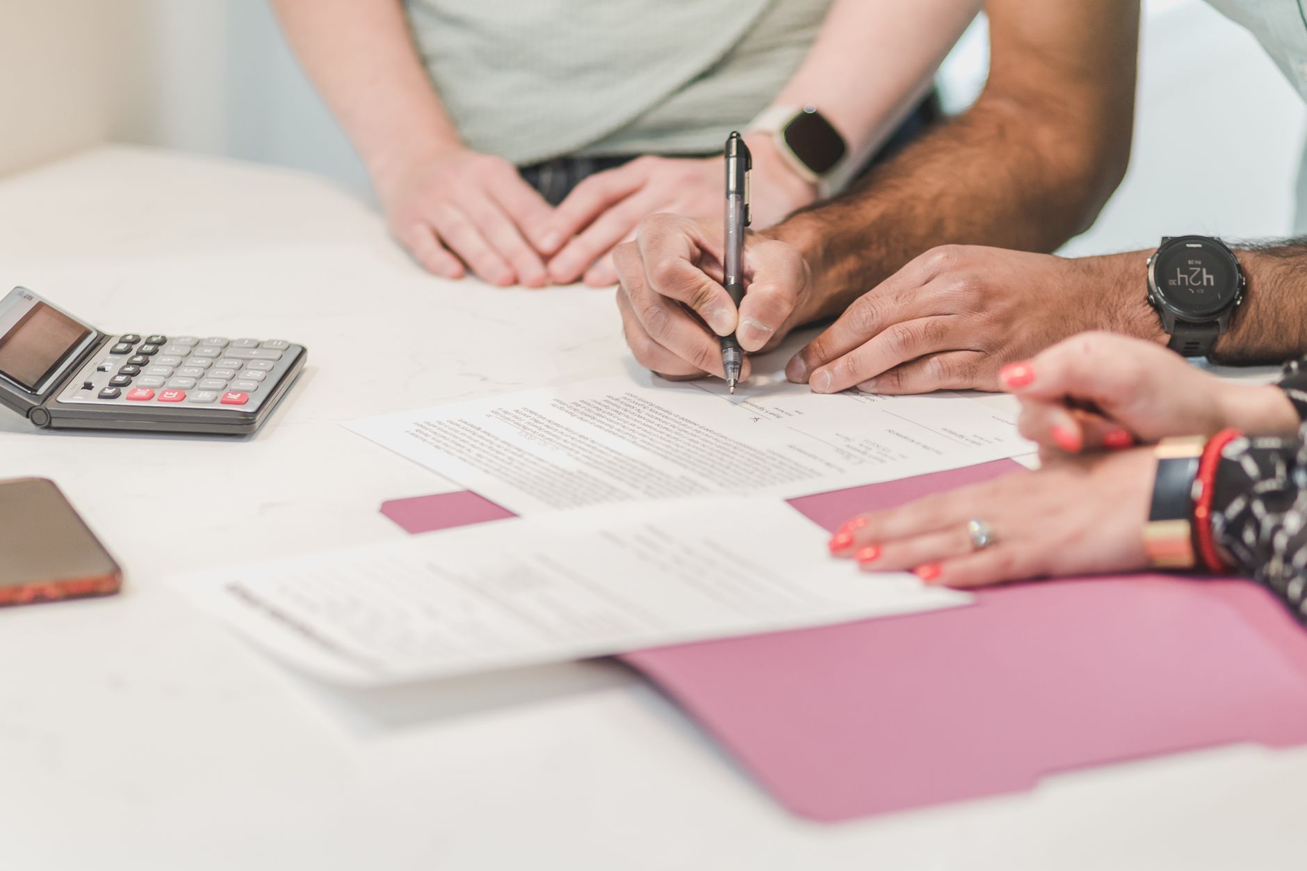Casal analisando papéis e calculadora antes de assinar um contrato
