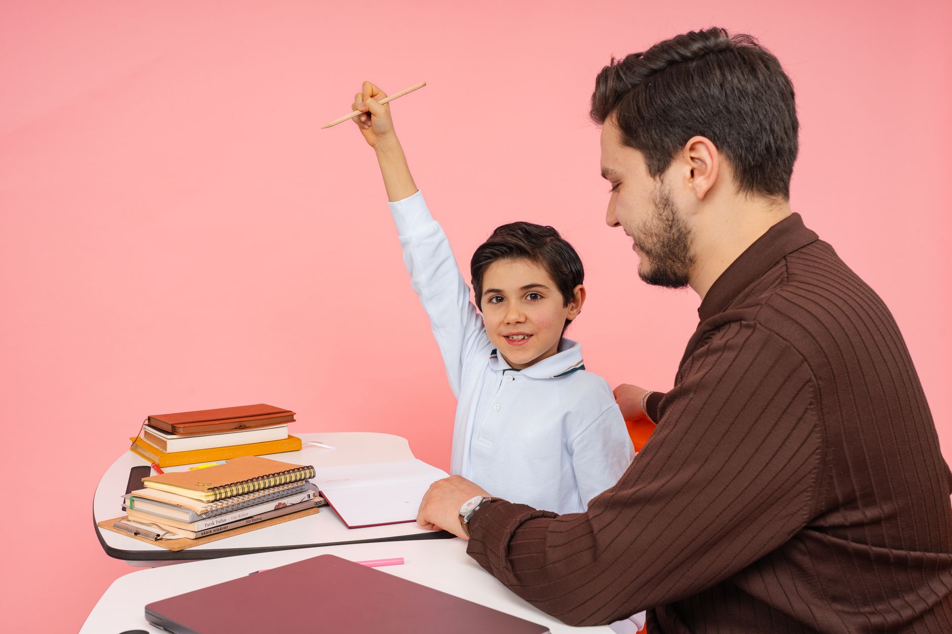 Professor e criança sorrindo durante uma aula com livros