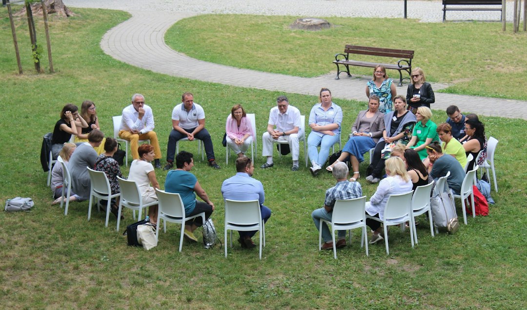 Grupo de pessoas sentadas em círculo em uma reunião comunitária ao ar livre