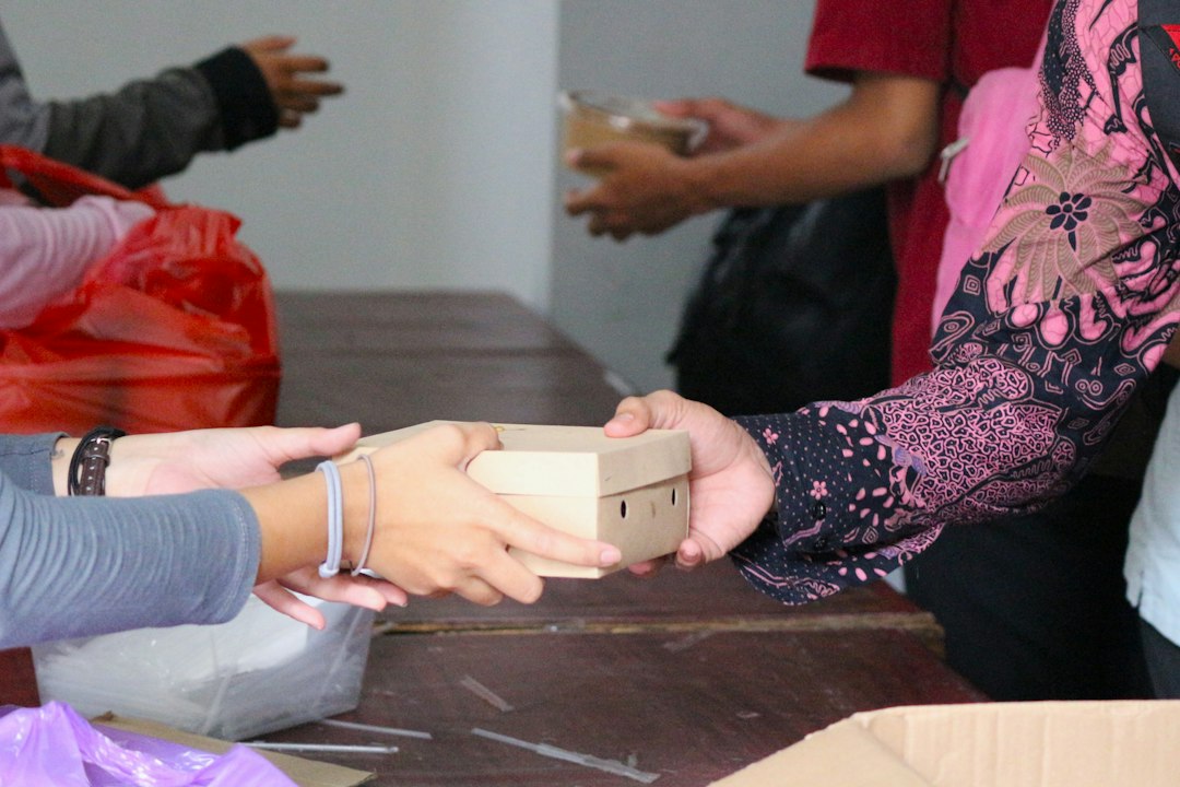 Mãos entregando uma contribuição em uma ação comunitária