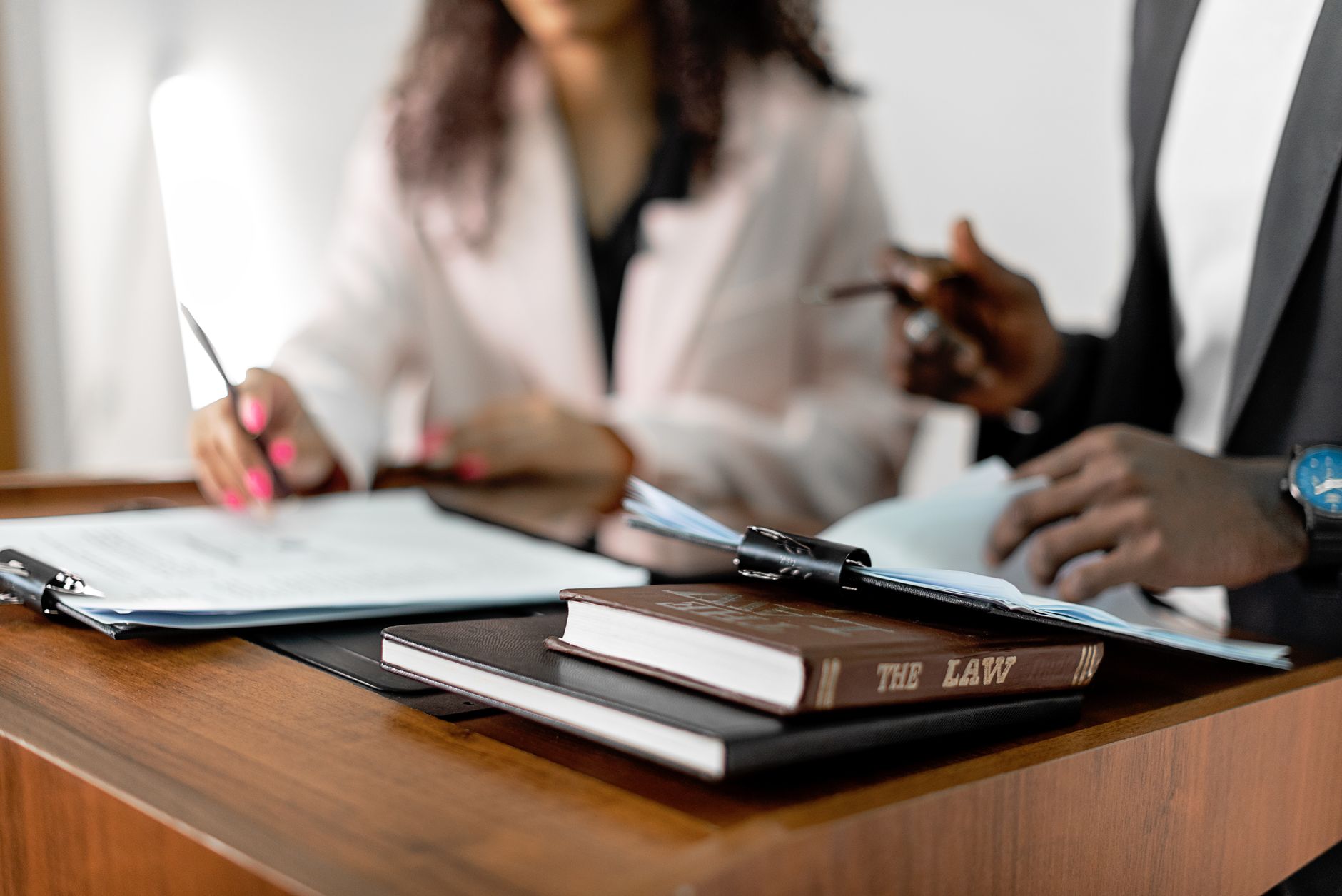 Mãos assinando documentos em uma mesa de escritório