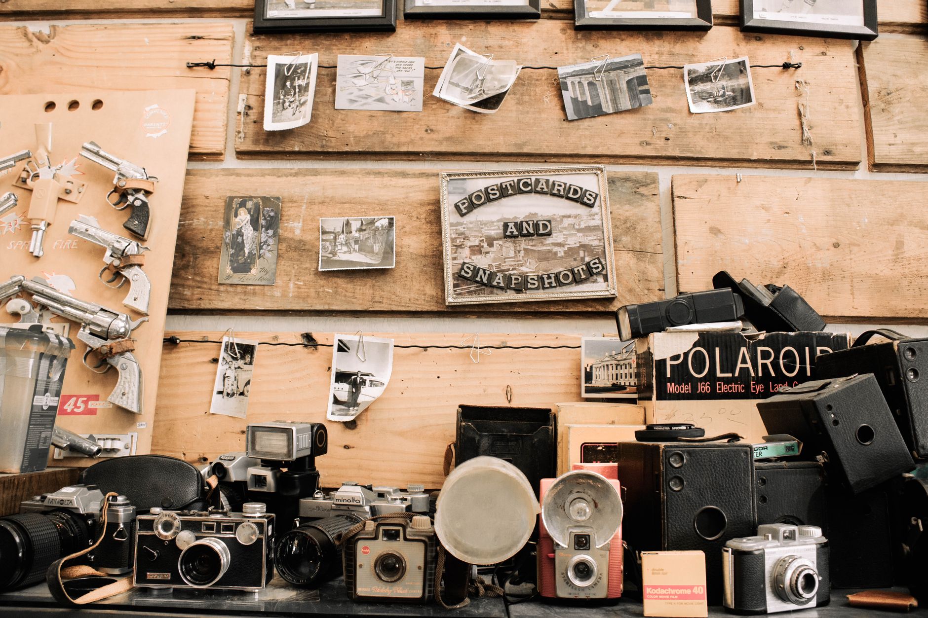 Câmeras fotográficas antigas e objetos de coleção sobre uma mesa de madeira