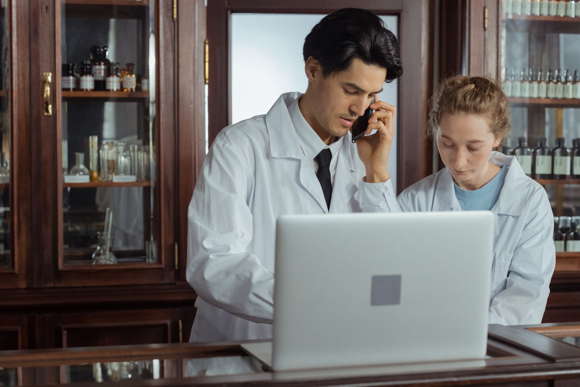 Farmacêuticos conferindo informações em um notebook no balcão