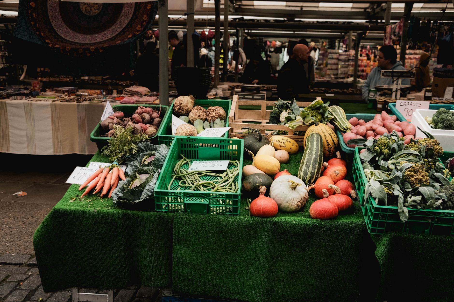 Banca de feira com legumes e verduras organizados em caixas