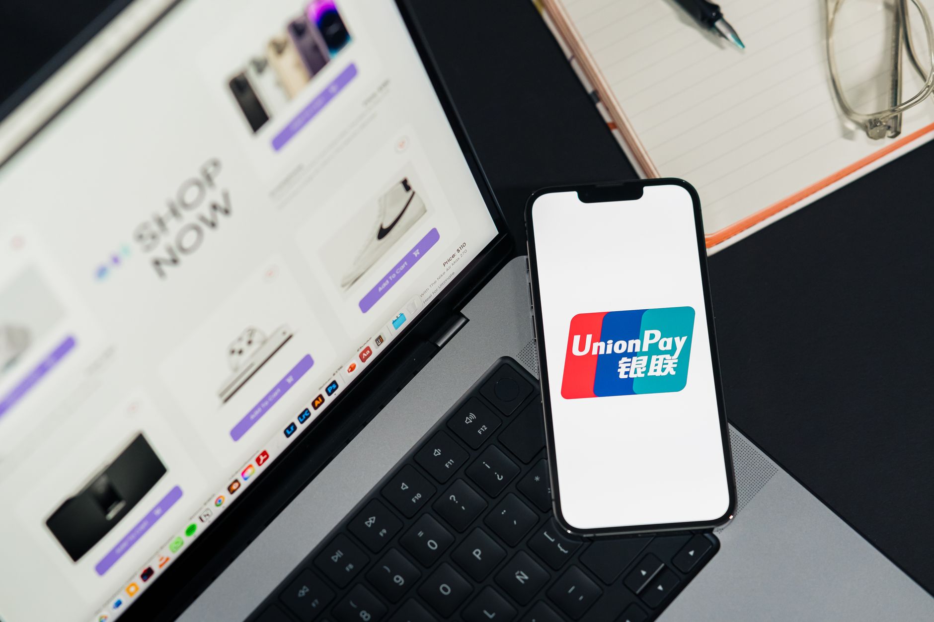 Mãos segurando cartão e celular para pagar uma compra online
