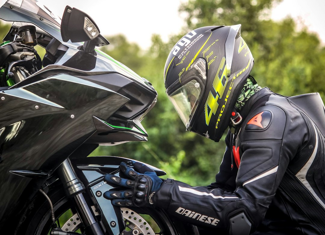 Motociclista de capacete ao lado da moto