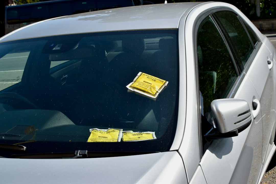 Aviso de multa preso no limpador de para-brisa de um carro