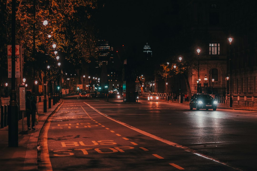 Avenida iluminada à noite com carros em movimento