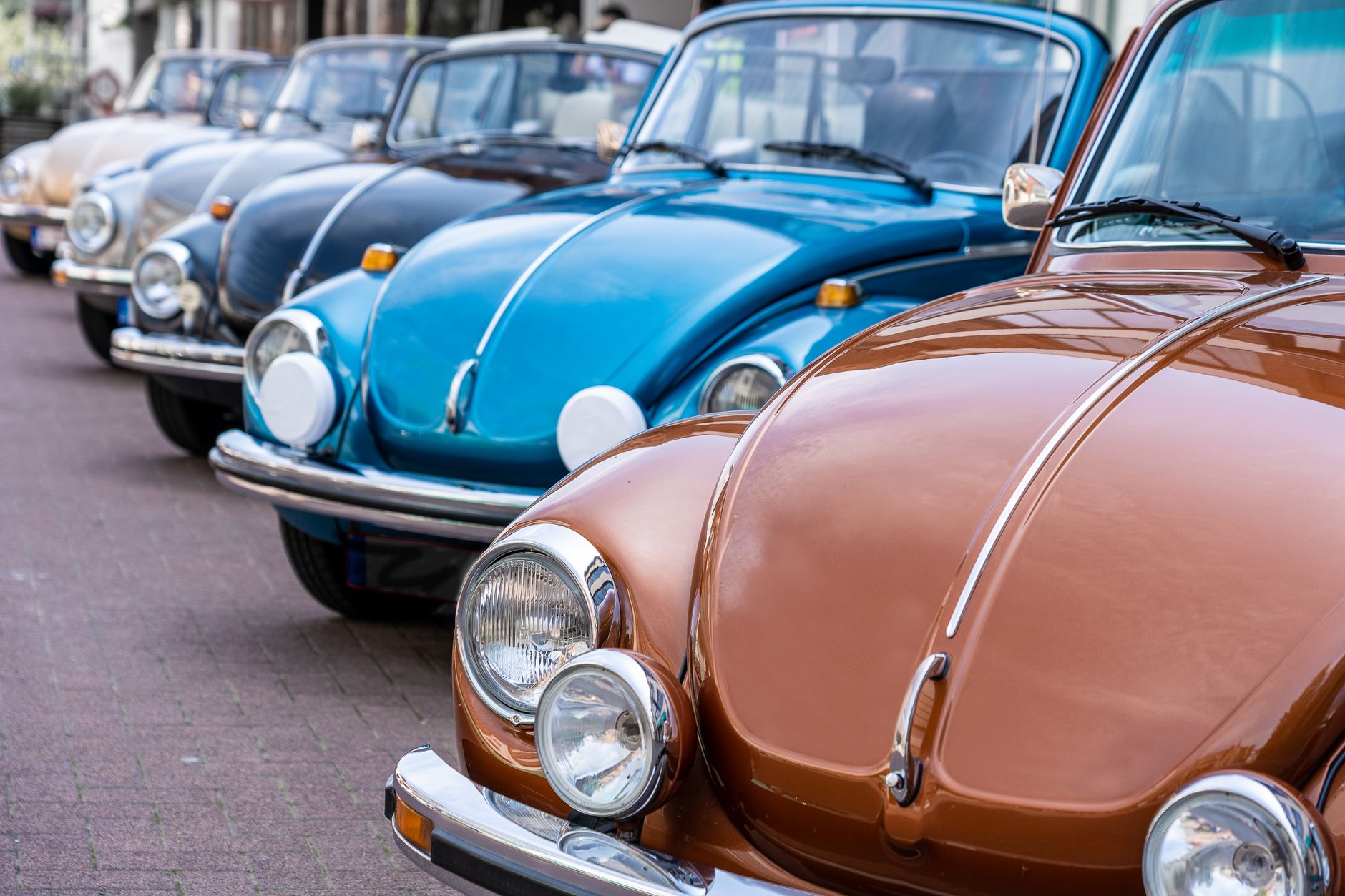 Fileira de fuscas coloridos estacionados lado a lado