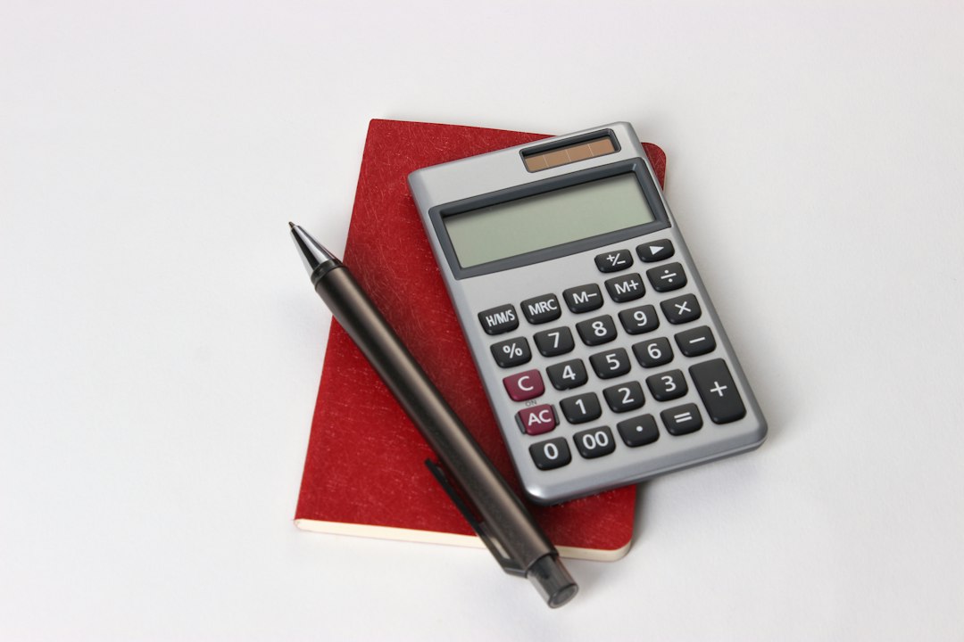 Calculadora sobre uma superfície vermelha com caneta