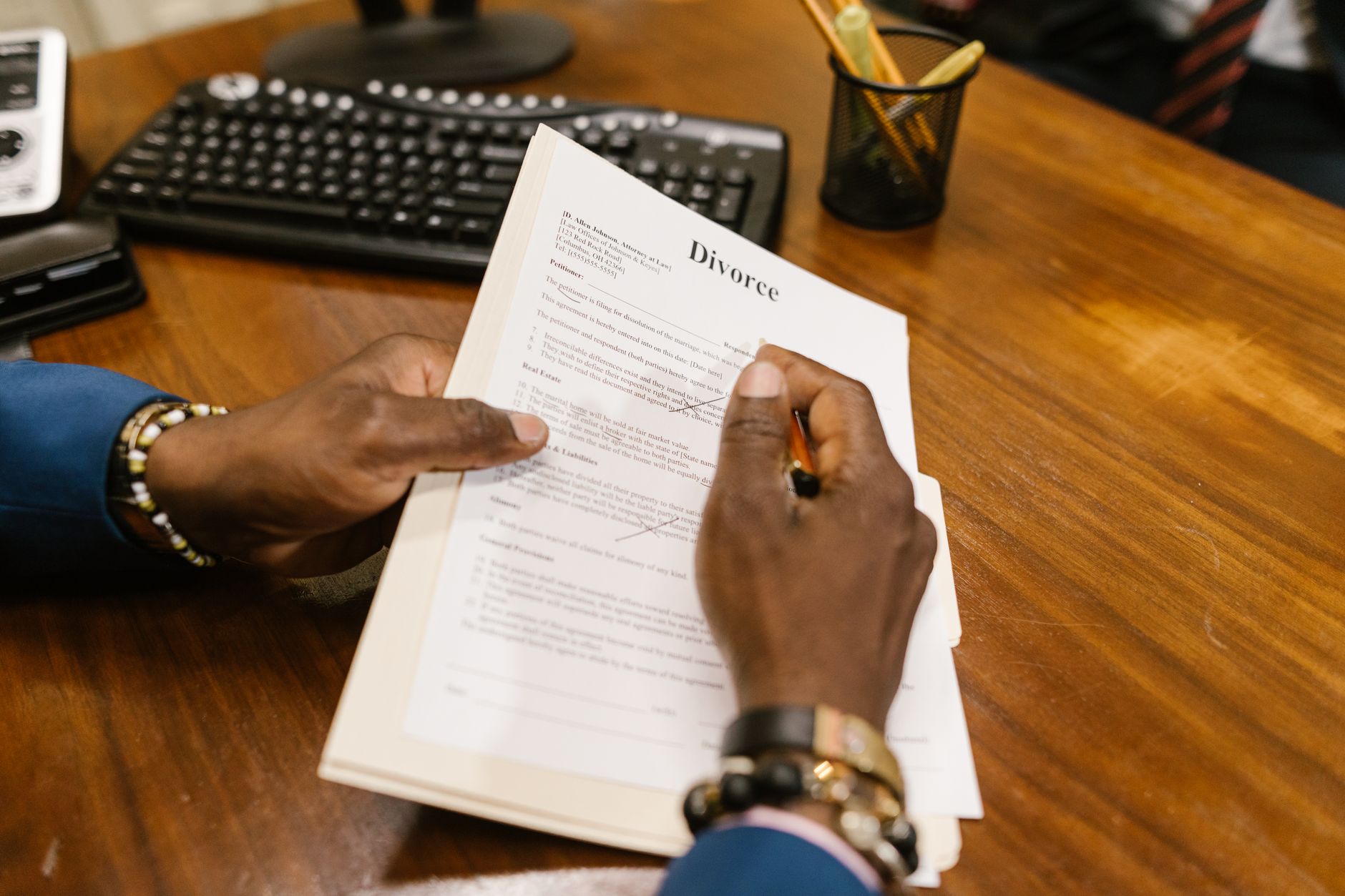 Mão assinando um documento sobre uma mesa