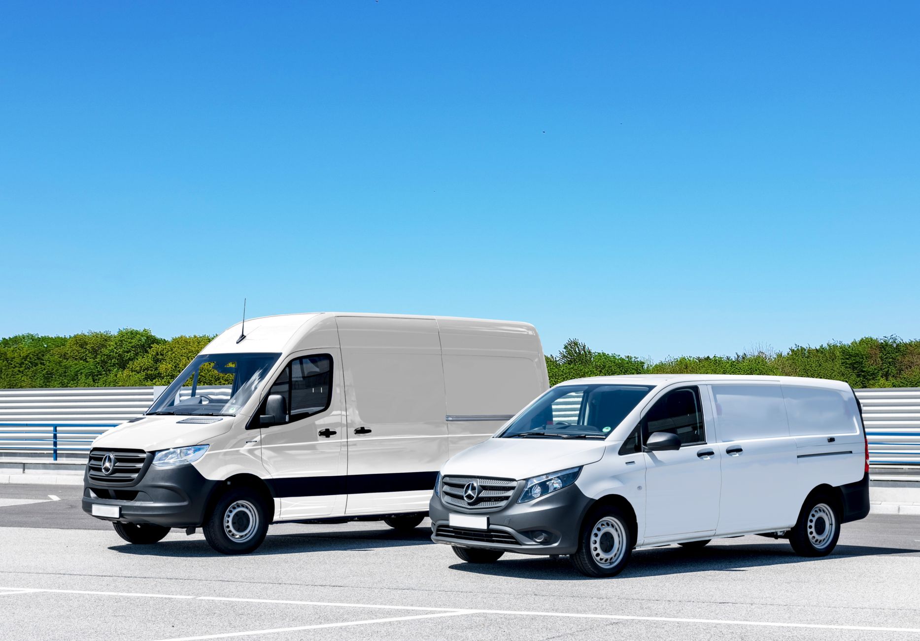 Duas vans brancas estacionadas sob céu azul