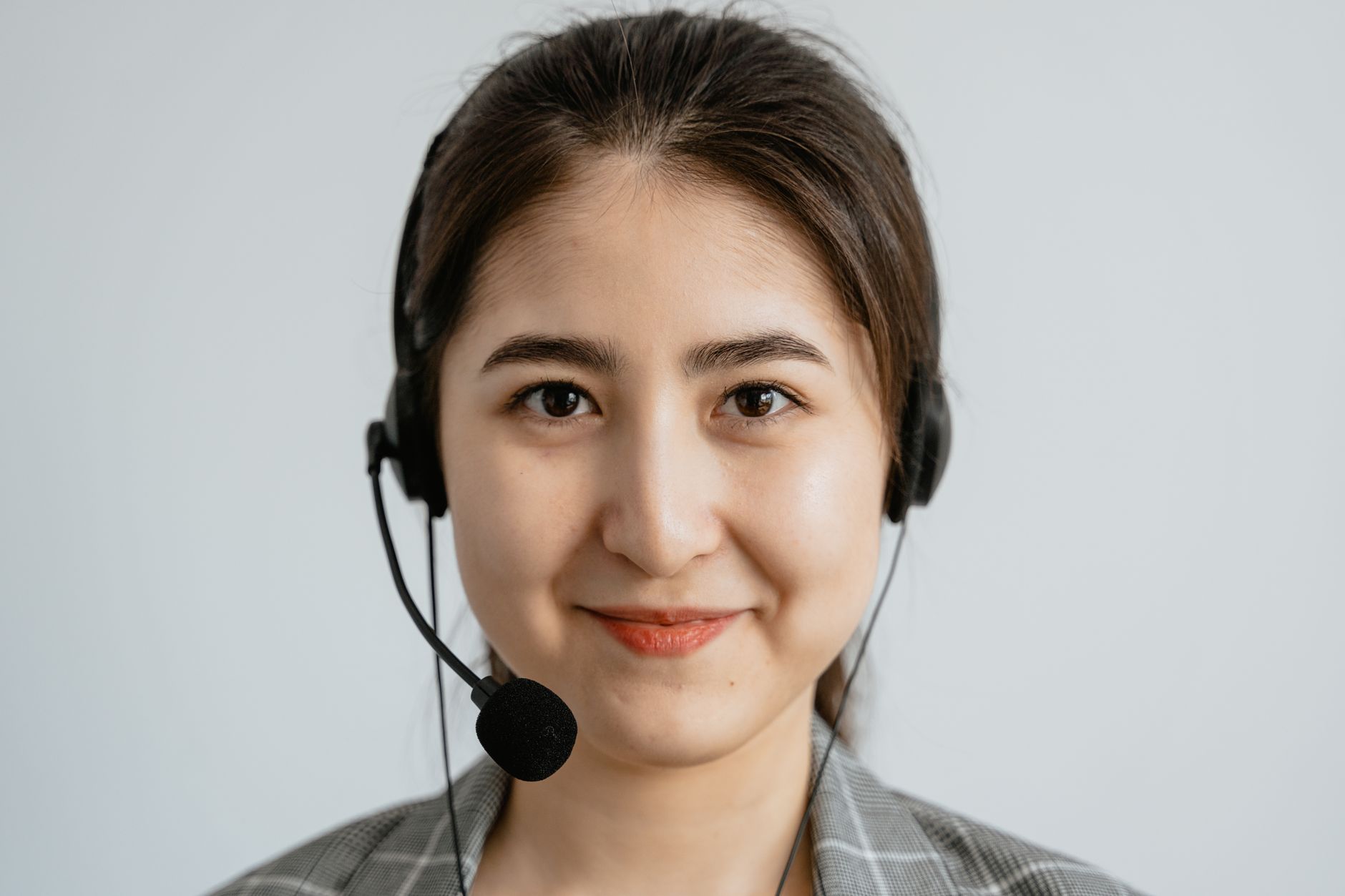 Atendente sorridente usando fone de ouvido em um escritório