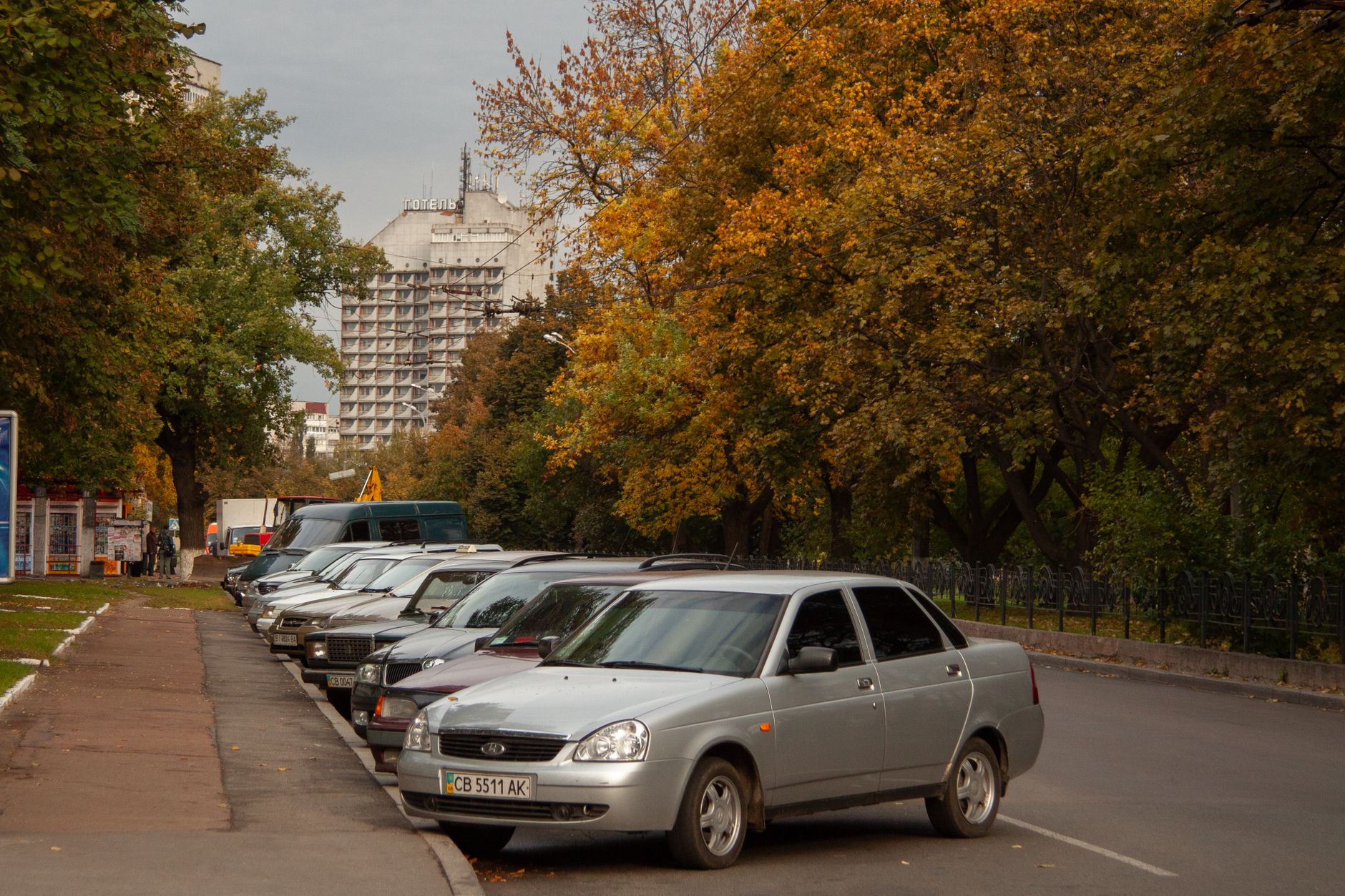 Carros estacionados em uma rua arborizada no outono